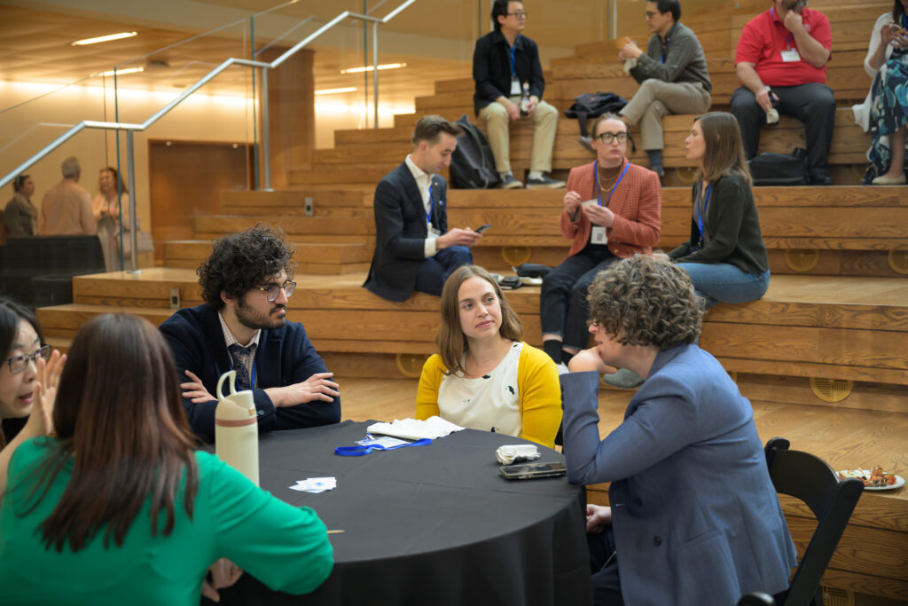 NEURO360 Symposium attendees talking at table