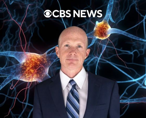 A person in a suit stands against a vibrant background of illuminated neurons. The CBS News logo is above, conveying a professional and scientific tone.